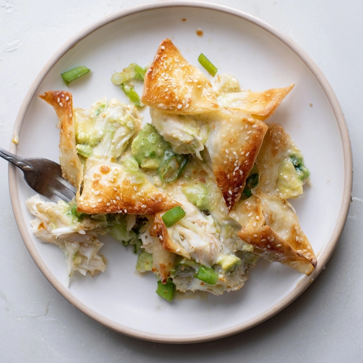 Golden Avocado Crab Rangoon Bake showing bubbly filling, crispy wontons, ready for a meal.