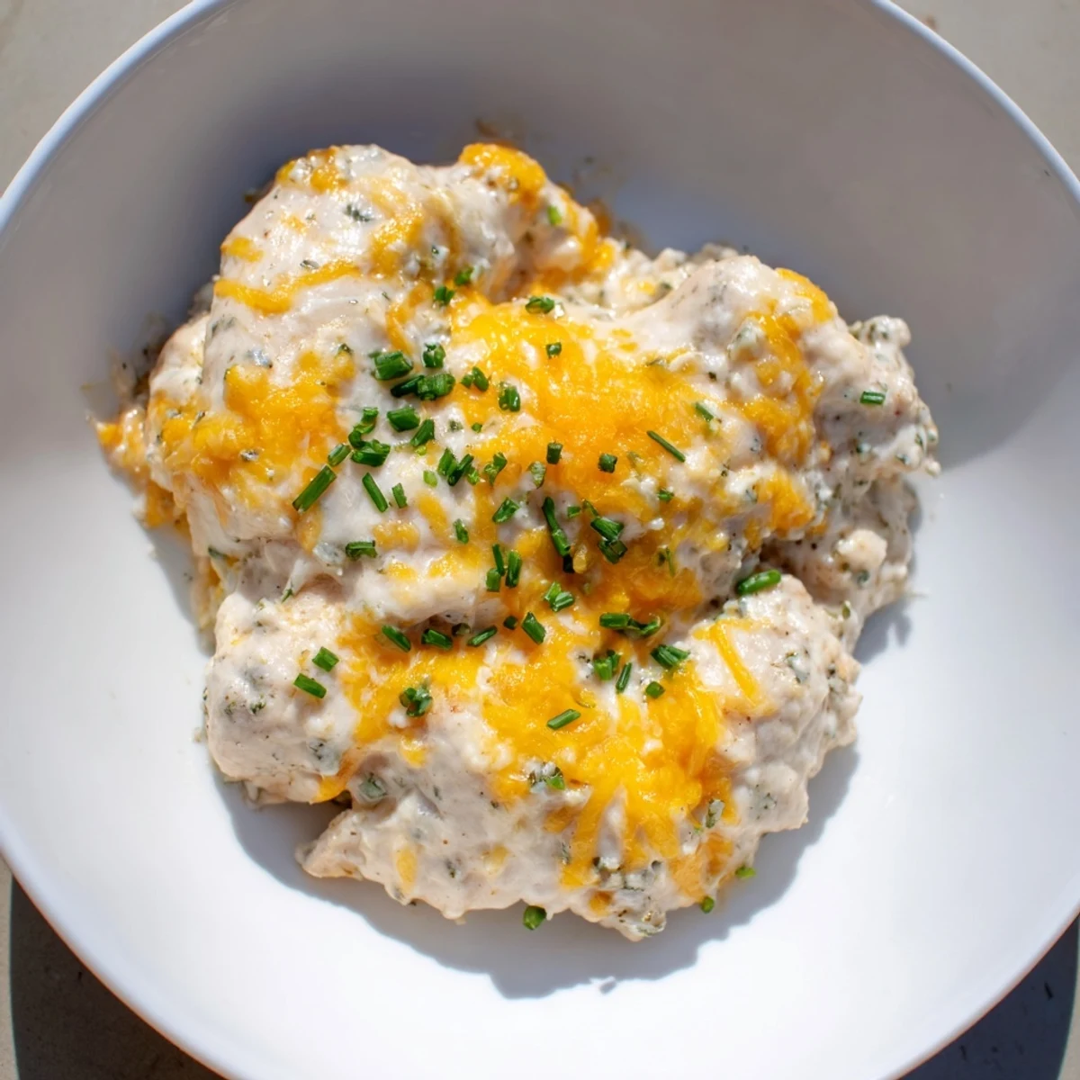 A creamy, cheesy Cheddar Ranch Chicken Bake topped with golden, bubbly cheddar cheese and fresh chives.