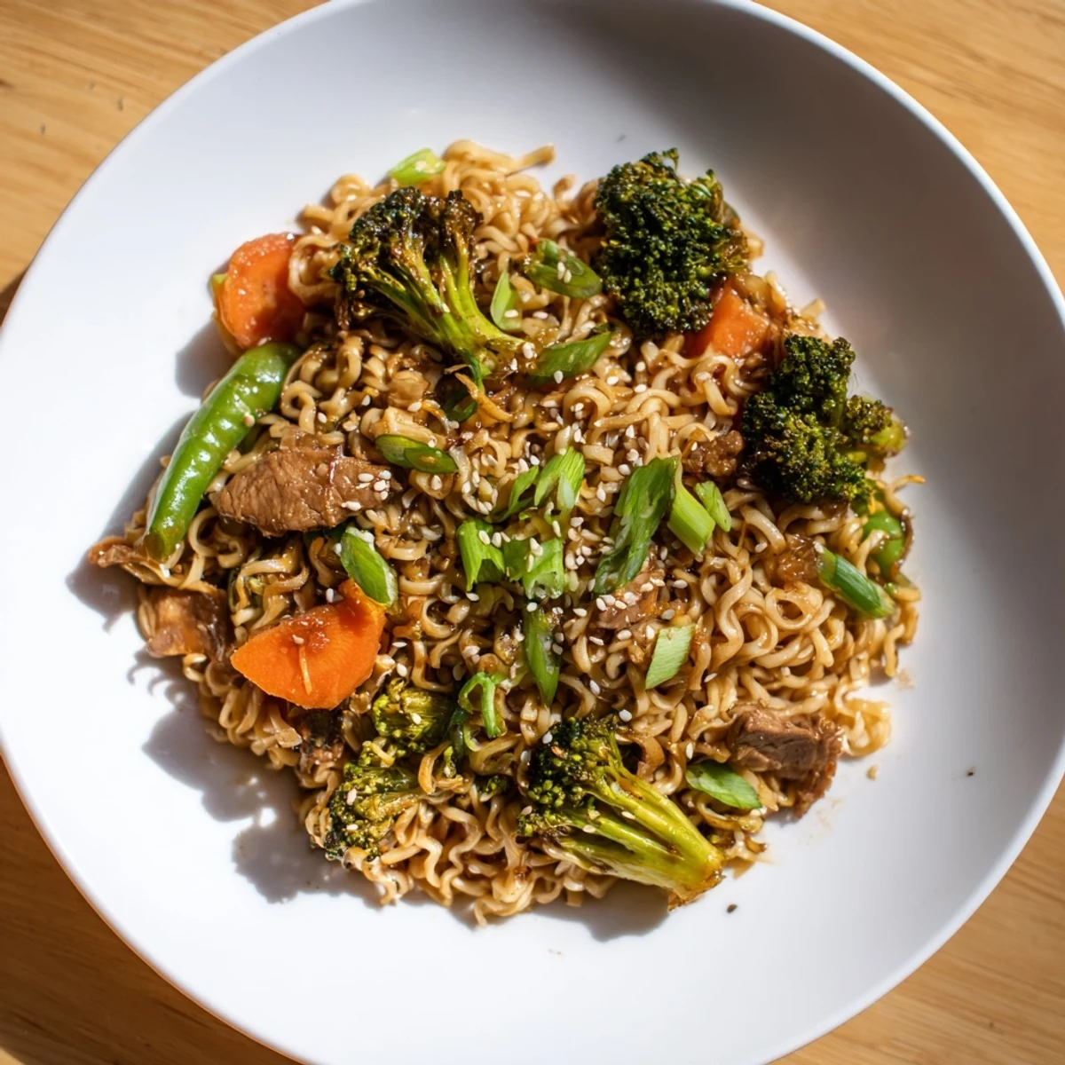 Flavorful Ramen Noodle Stir-Fry Remix, ready in 20 minutes, is garnished with sesame seeds and green onions.