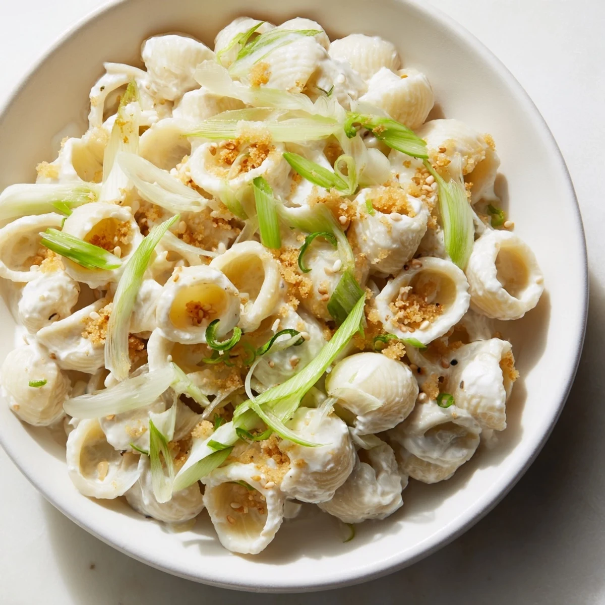 Steaming bowl of Japanese-inspired creamy miso ditalini, garnished with fresh scallions and sesame seeds.