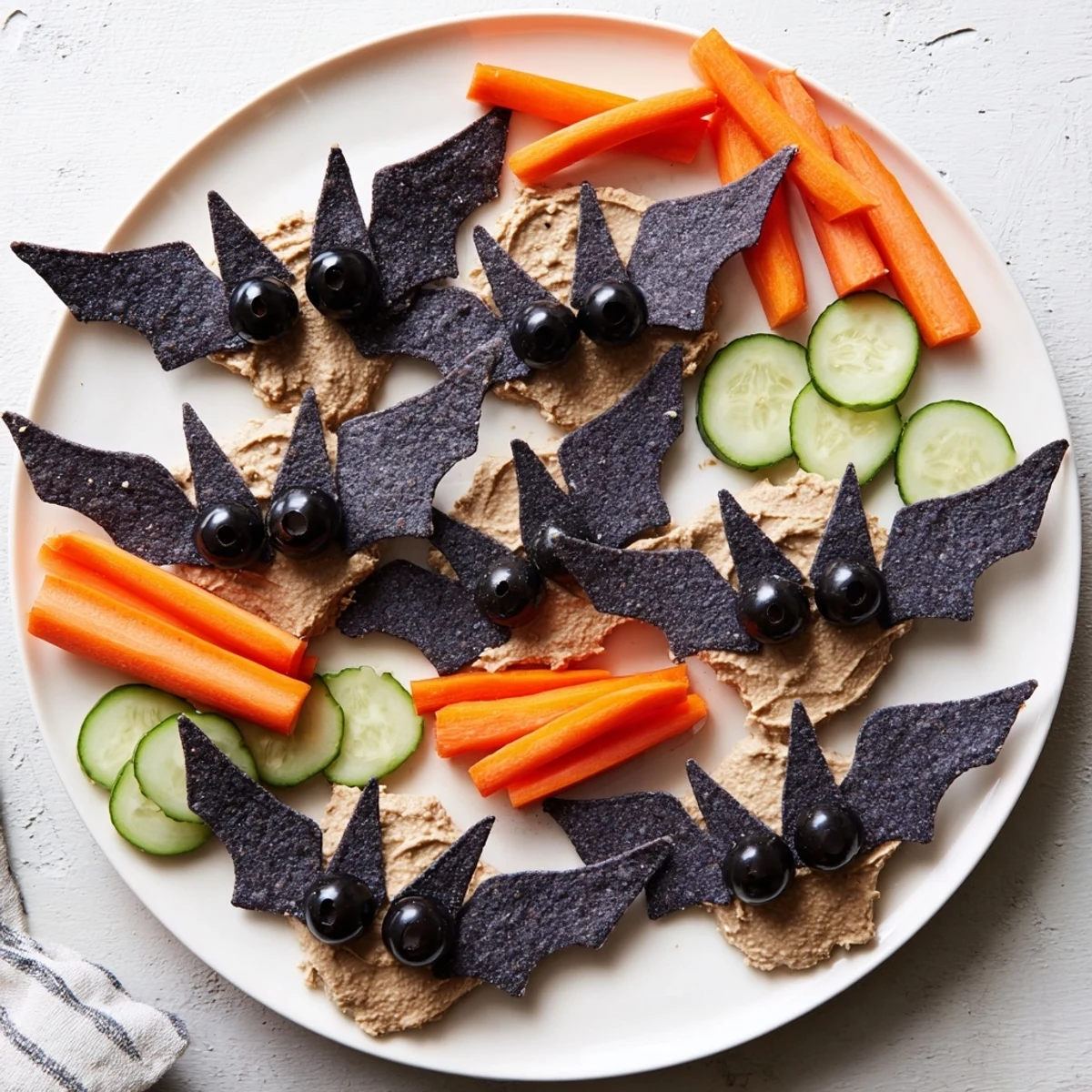 Creamy black bean dip shaped as spooky bats, a fun Spooky Bat Bean Dip Platter with chips & veggies.