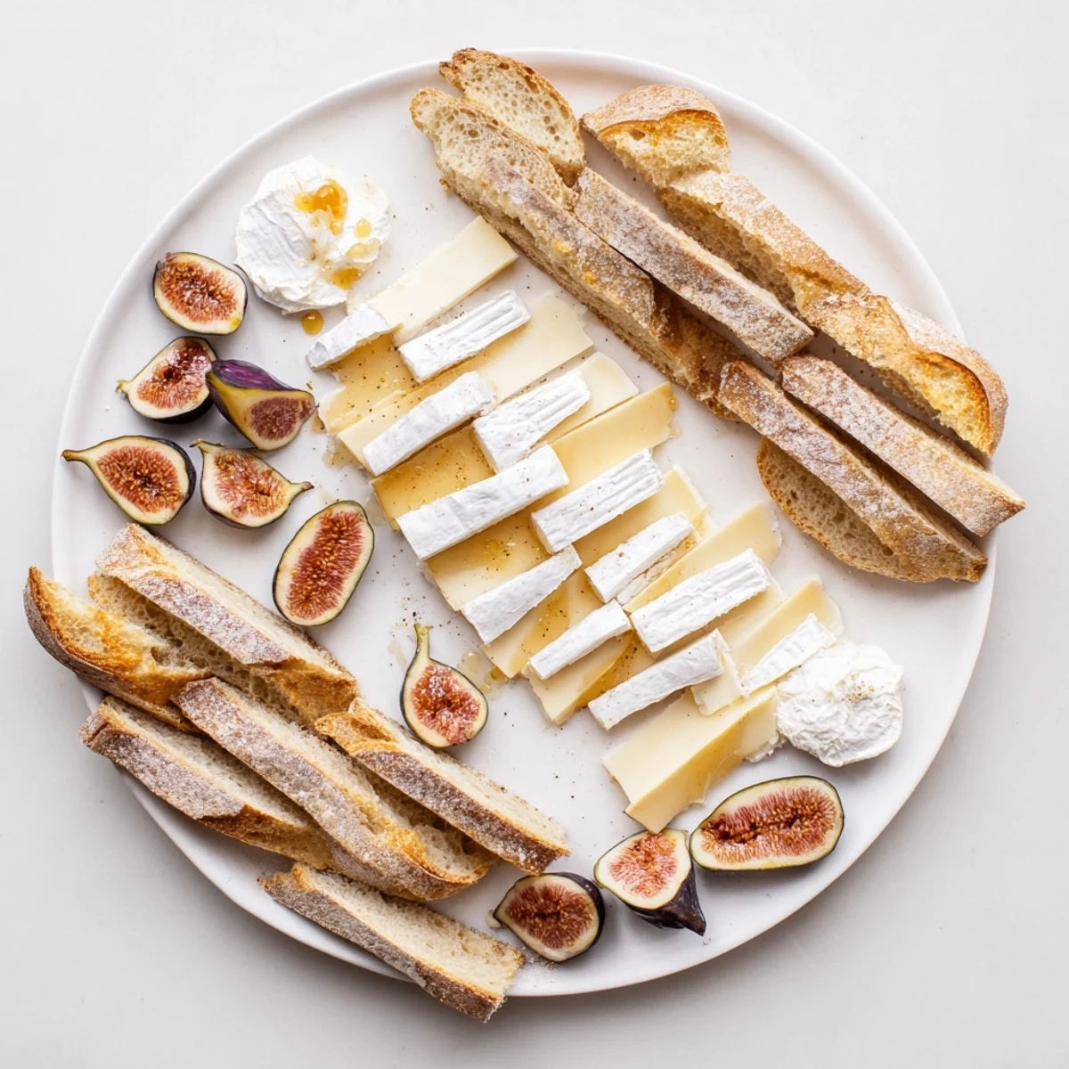 Freshly sliced French baguettes and cheeses compose this elegant French Bistro platter, ready to serve.