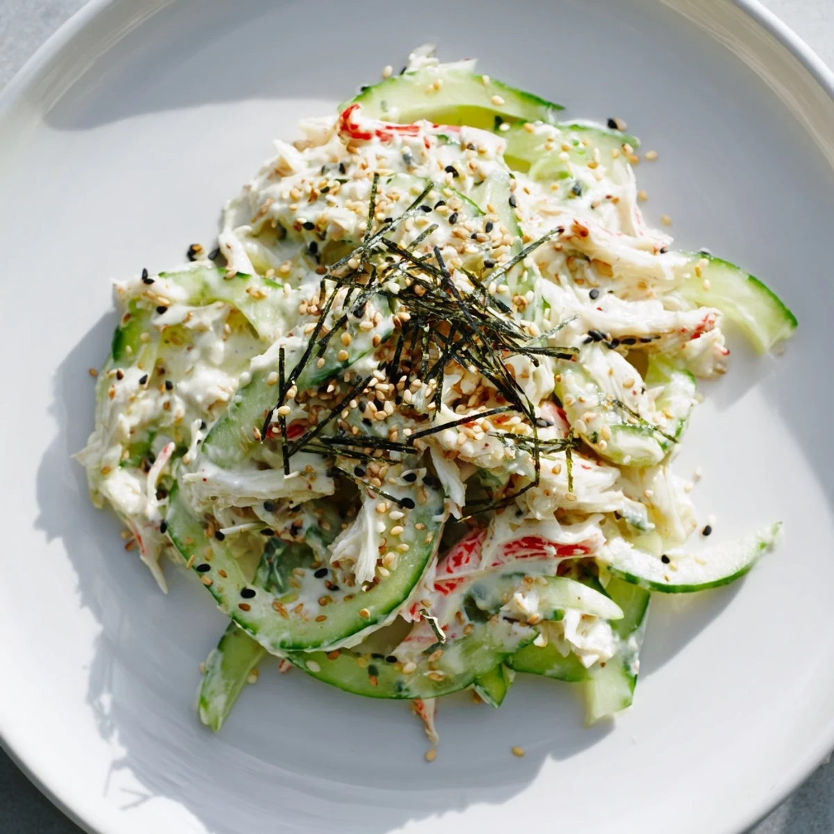 California Roll Cucumber Salad featuring fresh cucumbers, seasoned crab, and sesame seeds; a beautiful, refreshing dish.