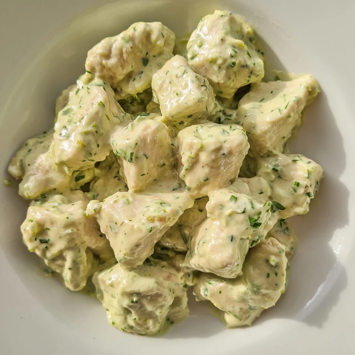 Cool, creamy Green Goddess Chicken Salad with baked chicken breast, fresh herbs, and cherry tomatoes served over mixed salad greens.