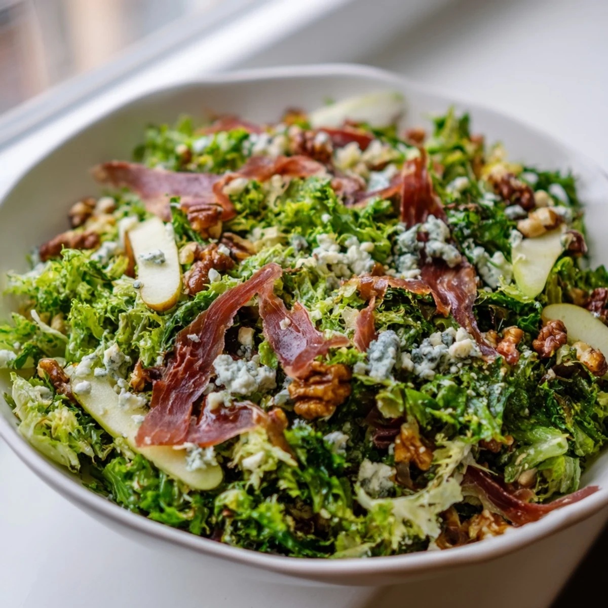 Golden, crispy prosciutto rests on a bed of frisée, pears, and blue cheese in this quick, gluten-free salad recipe.