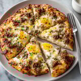 Warm Sausage Gravy Breakfast Pizza with scrambled eggs and melted cheddar, perfect weekend brunch.