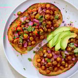 A close-up of BBQ chickpeas on toast, garnished with fresh herbs, a delicious, vegan meal.