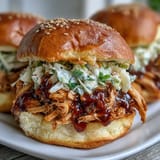 Smoky shredded chicken in rich barbecue sauce, topped with crisp coleslaw on toasted buns.  