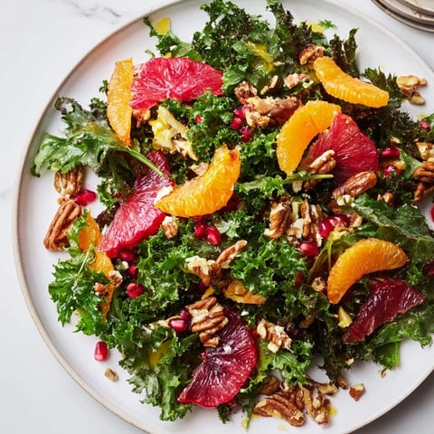 Vibrant Winter Greens Salad with citrus, pomegranate, and toasted nuts, a beautiful, colorful, refreshing dish.