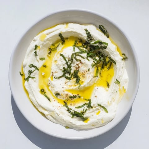 Creamy, smooth whipped feta dip with bright lemon-mint drizzle, ideal with pita bread.