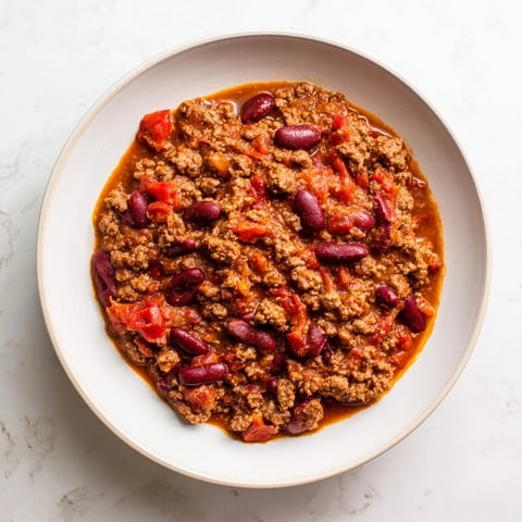 Steaming slow cooker chili, a comforting 4-Ingredient wonder, ready to serve with toppings.