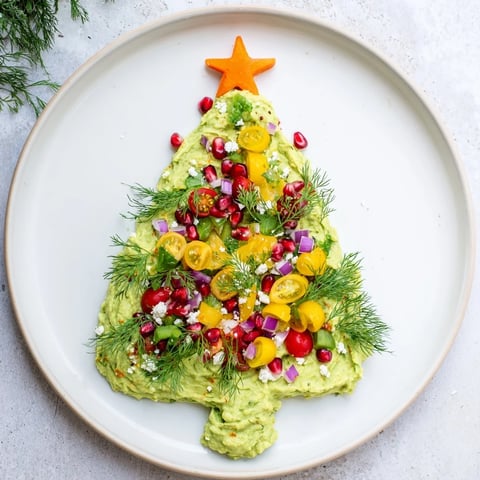 Creamy, festive whipped avocado Christmas tree dip decorated with colorful vegetables, perfect for holiday gatherings.