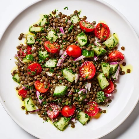 A refreshing lentil salad boasts tender lentils, bright tomatoes, and a zesty vinaigrette, ready to serve.