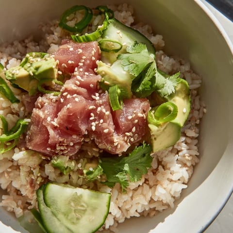 Creamy avocado and tender tuna chunks sit atop warm jasmine rice in this vibrant Tuna Avocado Rice Bowl, garnished with crisp cucumber and sesame seeds.