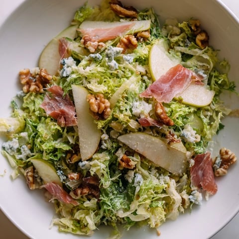 Glistening pear slices and crumbled blue cheese nestle among frisée leaves, topped with crispy prosciutto shards for this elegant salad.
