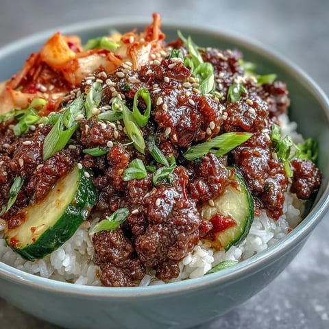 Steaming Korean Ground Beef Bowl with gochujang beef, edamame, and sesame seeds over rice.