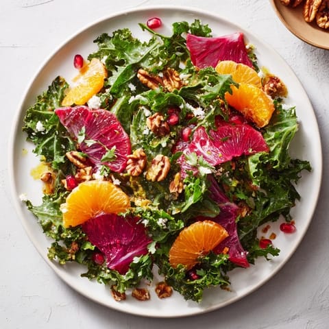 This Winter Greens Salad recipe features crunchy toasted nuts and juicy citrus segments atop mixed fresh greens.