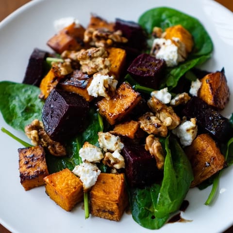Freshly tossed roasted beet and butternut salad, drizzled with balsamic vinaigrette, ready to serve.