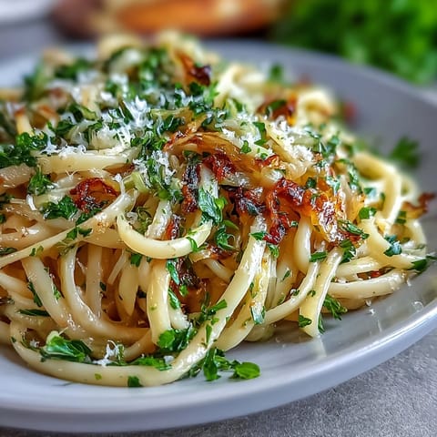 Twisted pasta strands coated in garlicky cabbage, served warm with lemon zest and extra Parmesan.