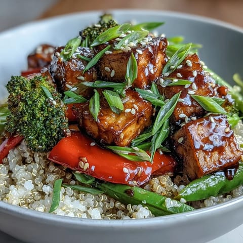 Golden crispy tofu cubes and vibrant stir-fried veggies garnished with sesame seeds and green onions.