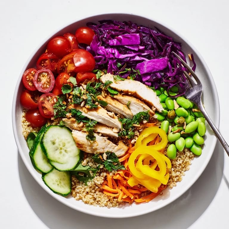Colorful meal-prep bowls featuring quinoa, fresh vegetables, and a zesty dressing.